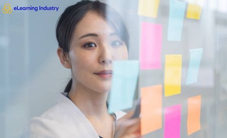 A woman looking at the viewer through a glass door with colorful sticky notes 